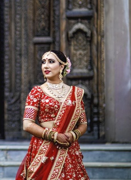 Bridesmaid in Traditional Red Bridal Lehenga at Wedding Venue.