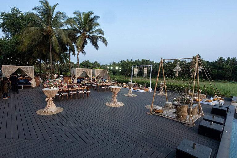 Beachside outdoor wedding setup with elegant decor and lighting.