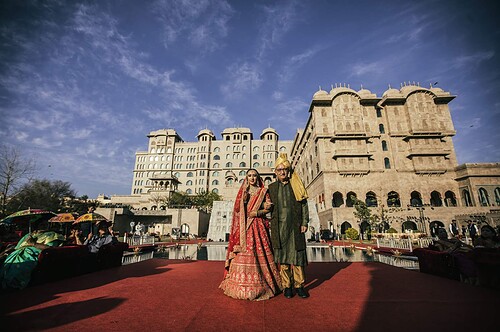 Elegant Indian bride and groom at wedding venue, luxurious Rajasthan palace wedding photography.
